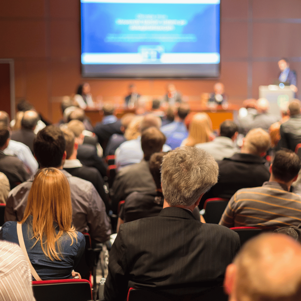 A conference room full of people watching a presentation